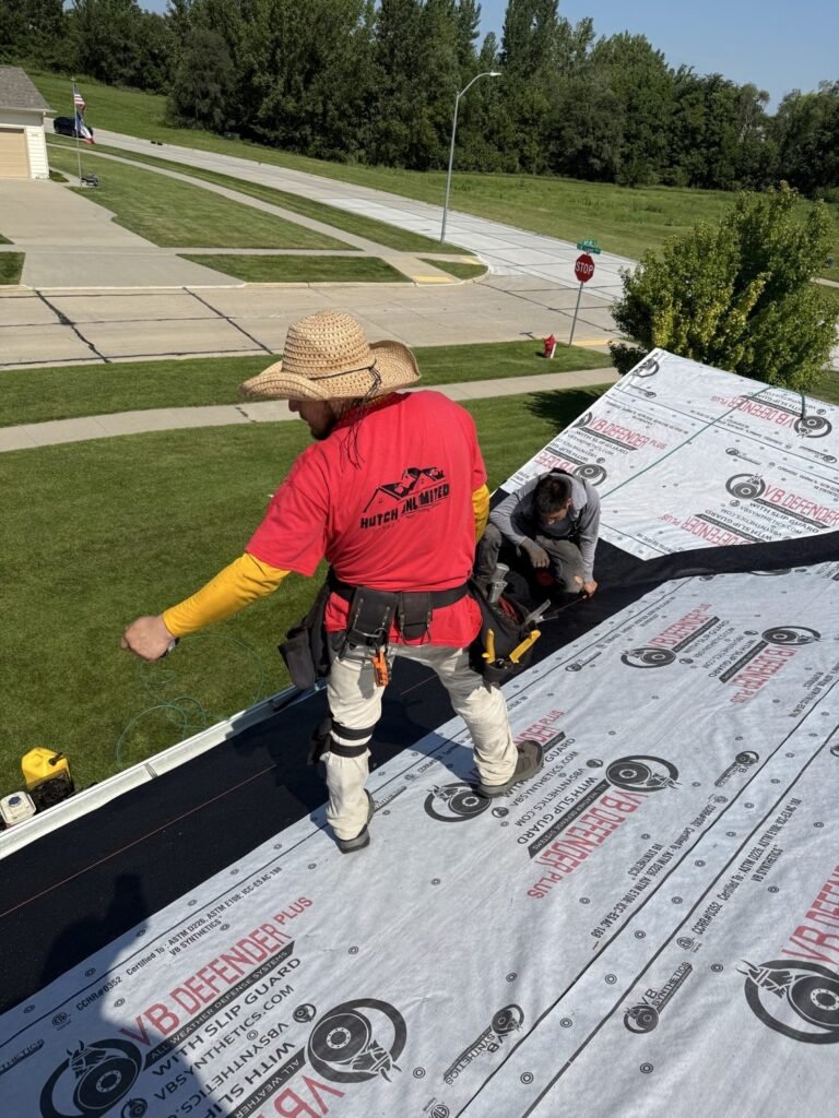 Hutch Unlimited Roofing crew installing synthetic underlayment on a roof replacement in Grimes, Iowa