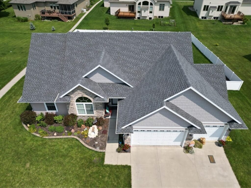Drone view of new gray shingle roof on a suburban home by Hutch Unlimited Roofing, Iowa