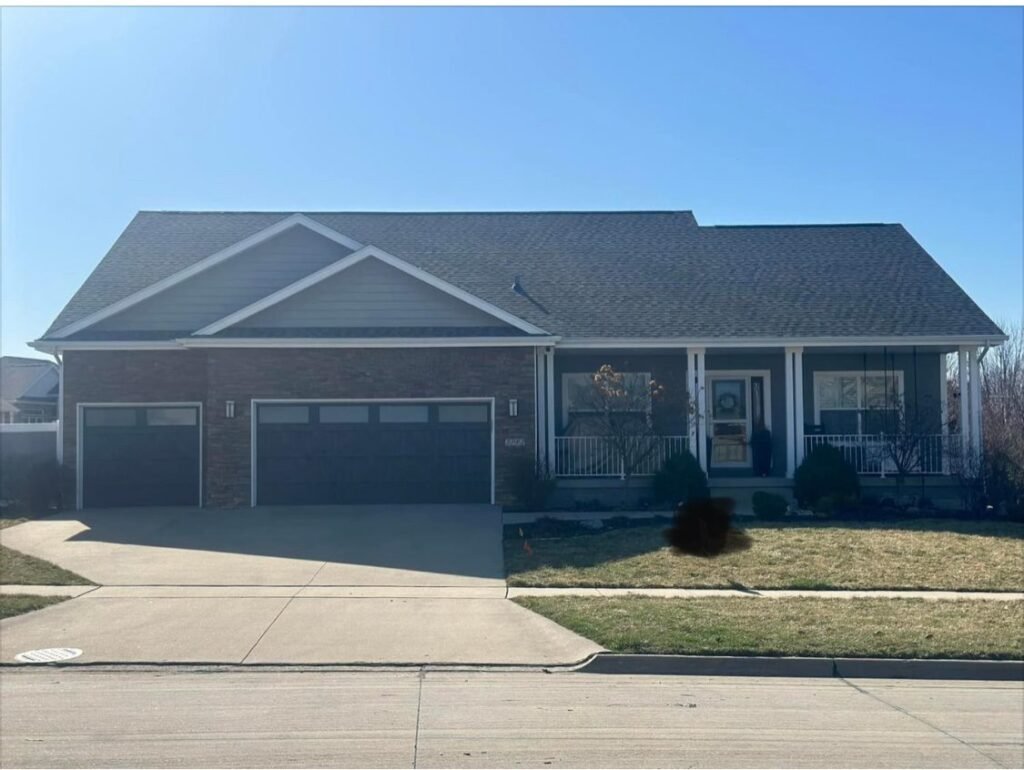New gray shingle roof on a ranch home with brick garage by Hutch Unlimited Roofing, Iowa
