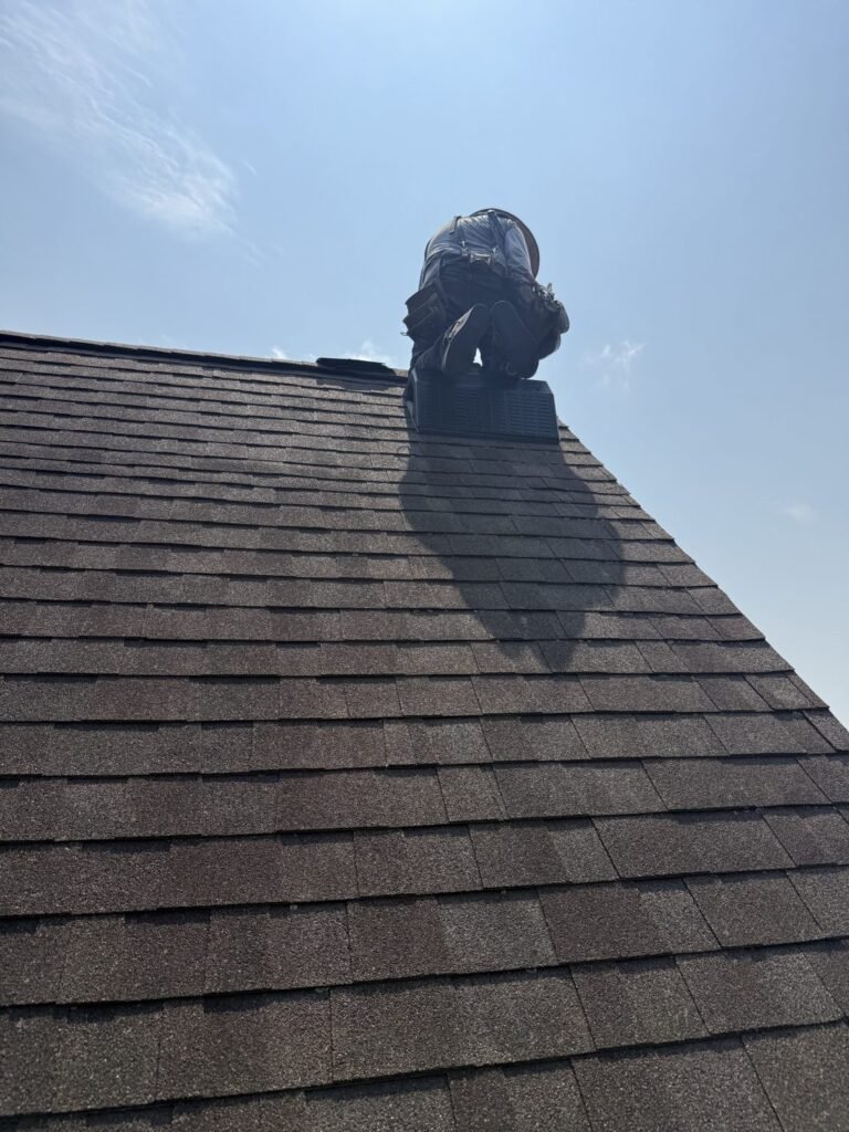 Roofer installing a ridge vent on a new shingle roof in Central Iowa