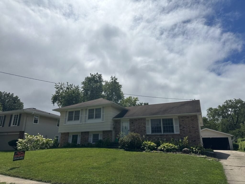Split-level home with old worn roof before replacement by Hutch Unlimited Roofing, Iowa