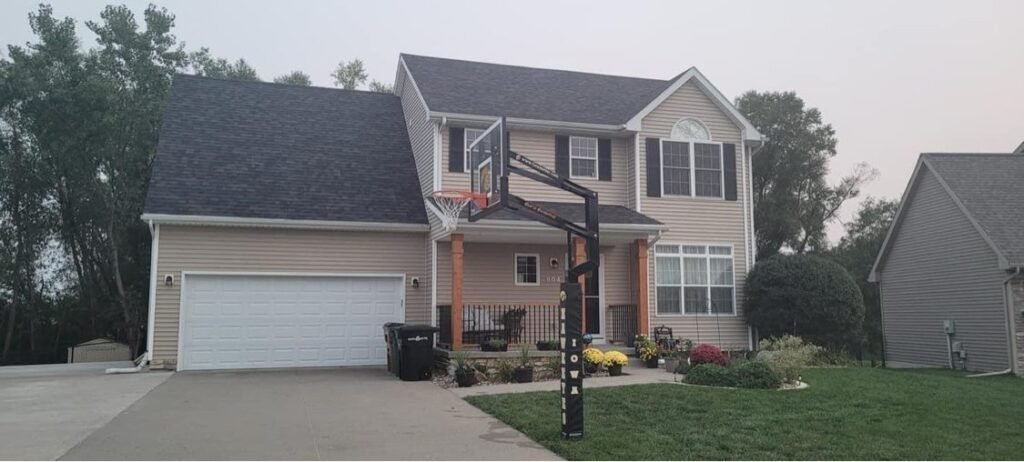 New dark shingle roof on a two-story suburban home by Hutch Unlimited Roofing, Iowa
