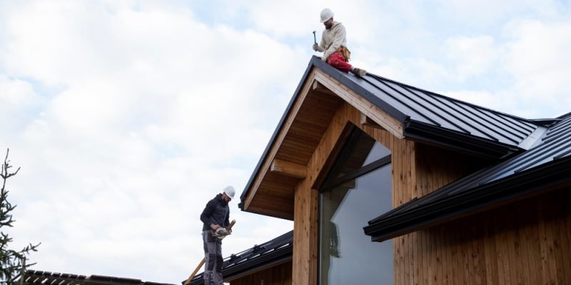 Roofer repairing asphalt shingles on a Des Moines home